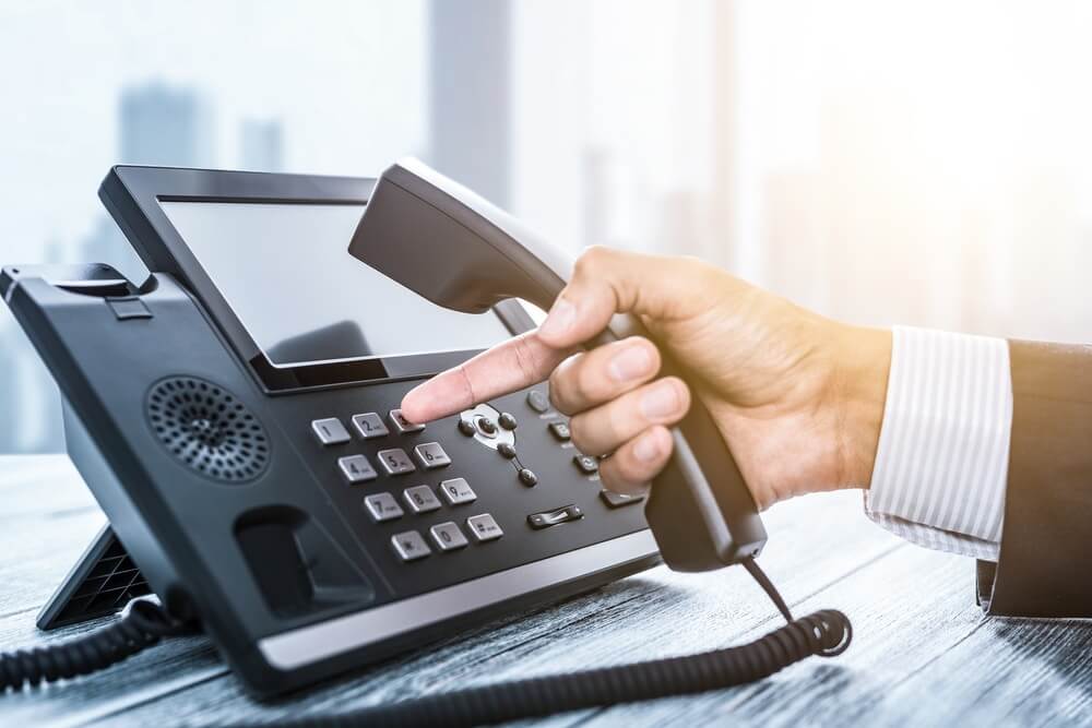 B2B sales rep using headset and script, applying effective cold call strategies in 2025